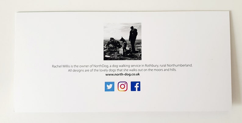 May include: Black and white photo of a person walking a dog on a moor. The text on the card reads "Rachel Willis is the owner of NorthDog, a dog walking service in Rothbury, rural Northumberland. All designs are of the lovely dogs that she walks out on the moors and hills. www.north-dog.co.uk" and includes social media icons for Twitter, Instagram, and Facebook.