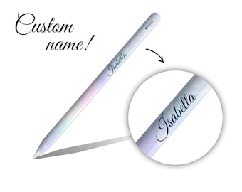 May include: A white Apple Pencil with a custom name, "Isabella", printed on it in black cursive. The pencil has a light blue and pink gradient design with a glittery effect.