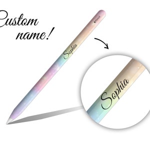 Op de afbeelding: Een regenboogkleurige Apple Pencil-huid met de naam "Sophia" geschreven in zwarte cursieve letters. De huid is ontworpen om op de Apple Pencil te passen.