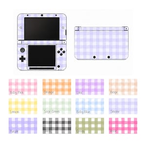May include: A lilac and white gingham-patterned Nintendo 3DS console skin, with a matching back panel. Below are color swatches in baby pink, orange, lilac, beige, lemon, sage green, baby blue, smoke, purple, black, green, and rose.