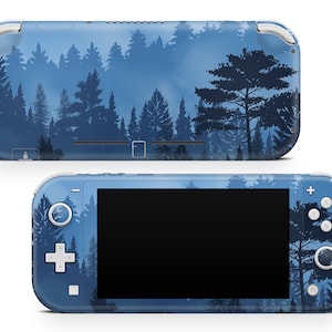 Puede incluir: Una consola Nintendo Switch Lite azul y blanca con un diseño de escena de bosque. La consola tiene una pantalla negra y botones blancos.