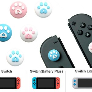 May include: A set of paw print-shaped button covers for the Nintendo Switch, Switch Lite, and Switch (Battery Plus) consoles. The covers are available in pink, blue, and white.