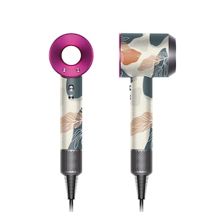 May include: Two hair dryers with different designs. One is a solid pink colour and the other has a white and grey floral pattern.