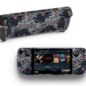 May include: A black and gray handheld gaming console with a custom skin featuring a Japanese-inspired wave and cherry blossom design. The console has a screen displaying the Steam interface with recent games.