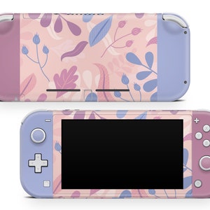 Puede incluir: Una consola Nintendo Switch Lite con un diseño floral. La consola presenta una combinación de colores rosa, lavanda y azul con un patrón de hojas y flores. La pantalla es negra.