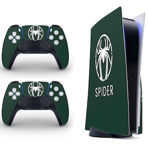 May include: A dark green gaming console and two matching controllers. Each controller and the console faceplate feature a white spider emblem. The word "SPIDER" is printed in white on the console faceplate.