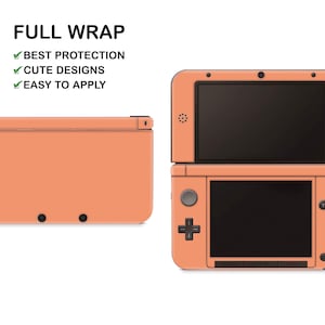 May include: A peach-coloured full wrap skin for a Nintendo 3DS. The skin covers the entire device, including the top and bottom screens, and features the text "FULL WRAP", "BEST PROTECTION", "CUTE DESIGNS", and "EASY TO APPLY".