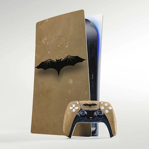 以下が含まれることがあります： 茶色と黒の配色で、黒いコウモリのシンボルが特徴のカスタムPlayStation 5コンソール。同じコウモリのシンボルが付いたコントローラーも付属しています。デザインは、使い古されたヴィンテージ感があります。