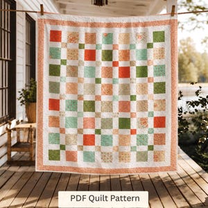 May include: A quilt featuring a grid of alternating solid and floral-patterned squares in shades of coral, sage green, and cream, bordered by a coral-colored frame. The text "PDF Quilt Pattern" is displayed at the bottom of the image.