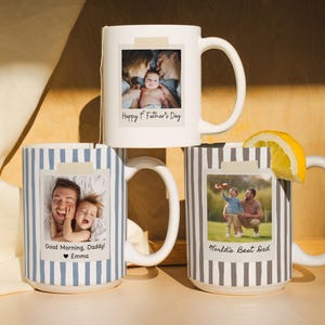 May include: Three white ceramic mugs featuring personalized photo prints. One mug is plain white with the text Happy 1st Father's Day. Two mugs have vertical stripes in blue or grey, with photo prints and the text Good Morning, Daddy! Emma or World's Best Dad.