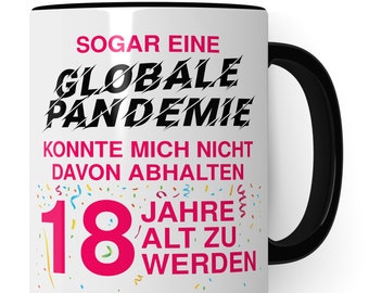 Può includere: Una tazza in ceramica bianca con un manico nero. La tazza ha un testo nero che recita "SOGAR EINE GLOBALE PANDEMIE KONNTE MICH NICHT DAVON ABHALTEN 18 JAHRE ALT ZU WERDEN". Il testo è in grassetto, nero. Il numero 18 è in rosa. Ci sono disegni di coriandoli colorati intorno al numero 18.