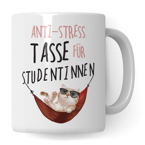 Könnte beinhalten: Weiße Keramiktasse mit einer schwarzen und rosa Grafik eines Katzen, das eine Sonnenbrille trägt und in einer Hängematte entspannt. Der Text "ANTI-STRESS TASSE FÜR STUDENTINNEN" ist auf die Tasse gedruckt.