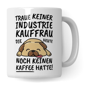 May include: White ceramic mug with a black and white illustration of a pug dog sleeping with the text "Traue keiner Industrie Kauffrau die heute noch keinen Kaffee hatte!"