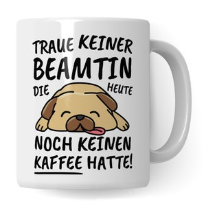 May include: White ceramic mug with a cartoon pug illustration and the text "Traue keiner Beamtin die heute noch keinen Kaffee hatte!"