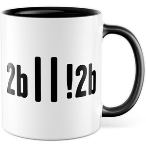 Könnte beinhalten: Weiße Keramik-Kaffeetasse mit schwarzem Rand und Henkel. Die Tasse hat einen schwarzen Text mit der Aufschrift "2b || !2b"