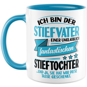 Peut inclure: Une tasse en céramique blanche avec un bord et une poignée bleus. La tasse présente un graphique avec le texte "Ich bin der Stiefvater einer unglaublich fantastischen Stieftochter... und ja, sie hat mir diese Tasse geschenkt."
