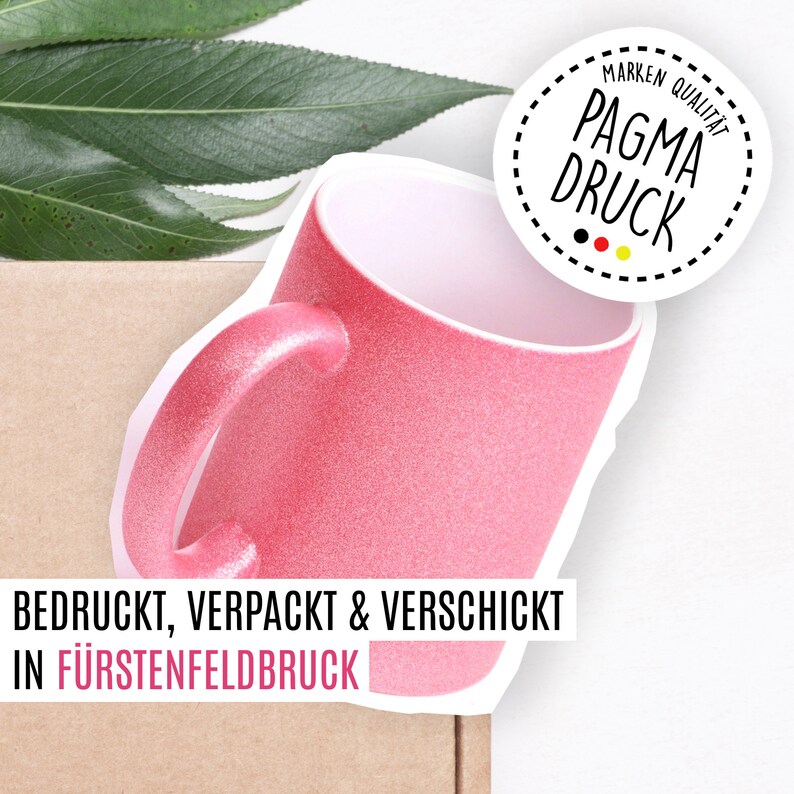 May include: A pink glitter mug with a white interior and a white handle. The mug is sitting on a brown cardboard box. The text "BEDRUCKT, VERPACKT & VERSCHICKT IN F&Uuml;RSTENFELDBRUCK" is printed on the box. A white circle with black dashed lines and the text "MARKEN QUALIT&Auml;T PAGMA DRUCK" is in the upper right corner of the image.