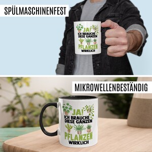 May include: White ceramic mug with a black rim and handle. The mug has a green and black illustration of various houseplants with the text "JA! ICH BRAUCHE DIESE GANZEN PFLANZEN WIRKLICH" printed on it.