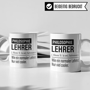 May include: Two white ceramic mugs with black text that reads "Philosophie Lehrer" and a definition of the word in German. The mugs are printed on both sides.