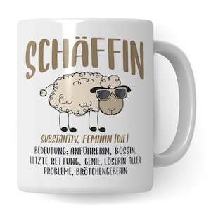 Peut inclure: Une tasse en céramique blanche avec un mouton de dessin animé brun portant des lunettes de soleil et le texte "SCHÄFFIN SUBSTANTIV, FEMININ (DIE) BEDEUTUNG: ANFÜHRERIN, BOSSIN, LETZTE RETTUNG, GENIE, LÖSERIN ALLER PROBLEME, BRÖTCHENGEBERIN"