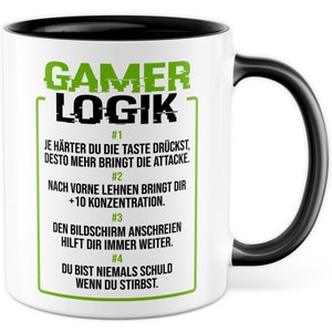 Pode incluir: Caneca de cerâmica branca com alça e borda pretas. A caneca tem um gráfico verde e preto que diz "Gamer Logik" e lista quatro regras para jogadores. As regras são numeradas de 1 a 4 e estão escritas em alemão.