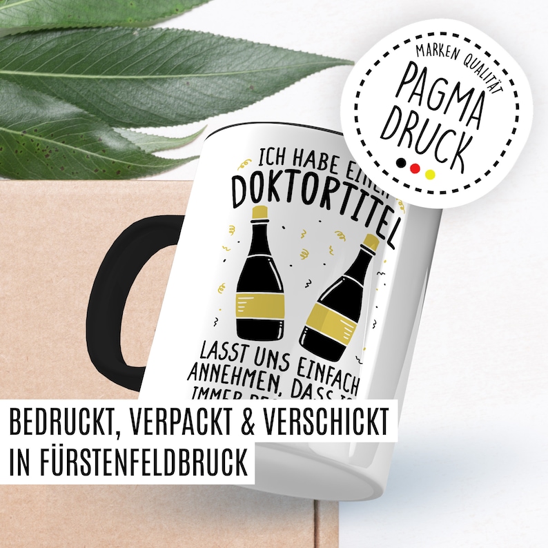 May include: White ceramic mug with a black handle. The mug has a graphic of two champagne bottles with the text "Ich habe einen Doktortitel" and "Lasst uns einfach annehmen, dass ich immer Recht habe". The mug also has a sticker with the text "Pagma Druck" and a German flag.