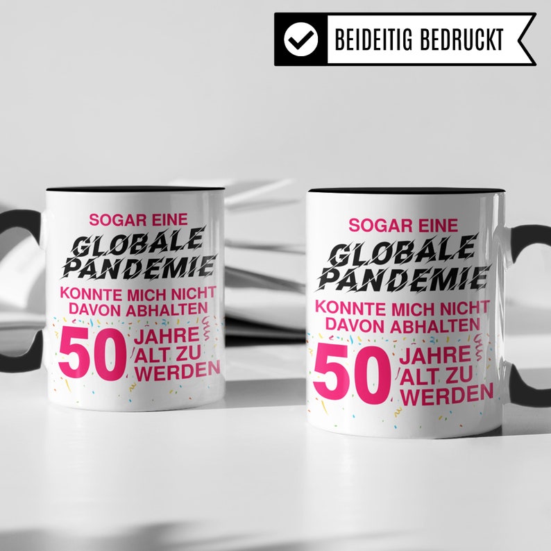 May include: Two white coffee mugs with black handles. Both mugs have a black rim and a design that says "Even a global pandemic couldn't stop me from turning 50." The text is in black and pink with confetti sprinkles around the number 50.