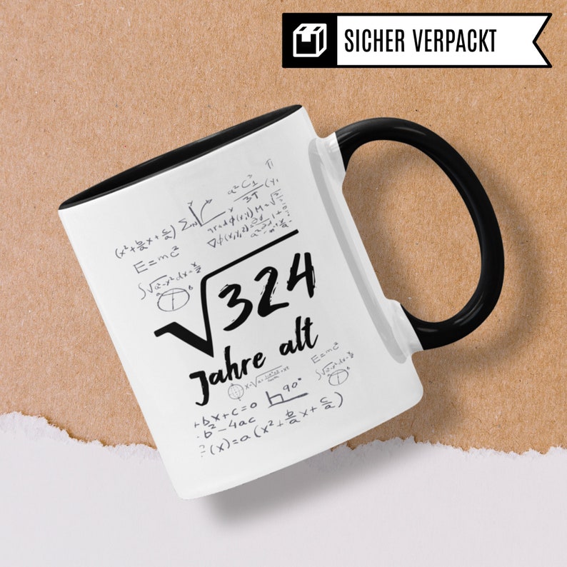 May include: White ceramic mug with a black handle. The mug has a black rim and features a black and white design of mathematical equations and the text "&radic;324 Jahre alt".