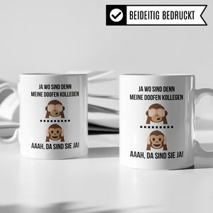May include: Two white mugs with black text and monkey illustrations. The text on the mugs reads "Ja wo sind denn meine doofen Kollegen" and "AAAH, da sind sie ja!"