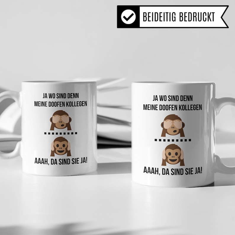 May include: Two white mugs with black text and monkey illustrations. The text on the mugs reads "Ja wo sind denn meine doofen Kollegen" and "AAAH, da sind sie ja!"