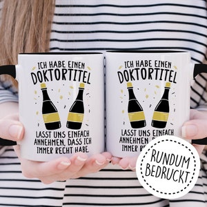 May include: Two white mugs with black handles and black rims. The mugs have a graphic of two champagne bottles with gold labels and the text "Ich habe einen Doktortitel" and "Lasst uns einfach annehmen, dass ich immer Recht habe." The mugs are held by a person's hands. A white circle with a black border and the text "RUNDUM BEDRUCKT" is in the lower right corner of the image.