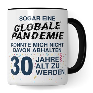 May include: White ceramic mug with a black handle. The mug has a black and white graphic that says "Sogar eine Globale Pandemie Konnte Mich Nicht Davon Abhalten 30 Jahre Alt Zu Werden".
