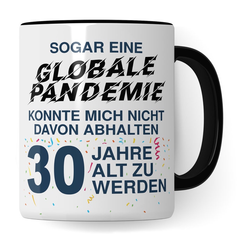May include: White ceramic mug with a black handle. The mug has a black and white graphic that says "Sogar eine Globale Pandemie Konnte Mich Nicht Davon Abhalten 30 Jahre Alt Zu Werden".