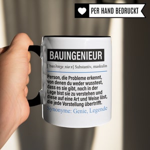 May include: White ceramic mug with a black handle and rim. The mug features a black and white graphic with the word "BAUINGENIEUR" in bold, followed by a definition in German. The text reads: "['bao?nze, ni&oslash;:e] Substantiv, maskulin Person, die Probleme erkennt, von denen du weder wusstest, dass es sie gibt, noch in der Lage bist sie zu verstehen und diese auf eine Art und Weise l&ouml;st, die jede Vorstellung &uuml;bertrifft. Synonyme: Genie, Legende"