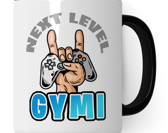 Könnte beinhalten: Eine weiße Keramik-Kaffeetasse mit schwarzem Henkel. Die Tasse zeigt eine graue Grafik einer Hand, die einen Videospielcontroller hält, mit dem Text "NEXT LEVEL GYMI" in Grau und Blau.