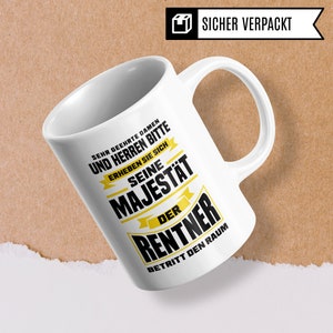 Puede incluir: Taza de cer&aacute;mica blanca con un dise&ntilde;o en negro y amarillo. El texto en la taza dice "Sehr geehrte Damen und Herren Bitte erheben Sie sich Seine Majest&auml;t Der Rentner Betritt Den Raum".