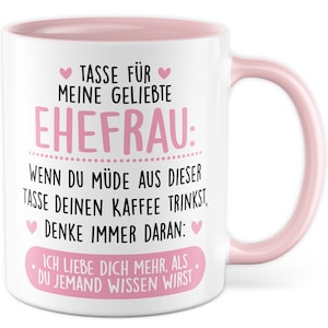 Könnte beinhalten: Weiße Keramiktasse mit rosafarbenem Rand und Henkel. Die Tasse hat ein rosa Herz und den Text "TASSE FÜR MEINE GELIEBTE EHEFRAU: WENN DU MÜDE AUS DIESER TASSE DEINEN KAFFEE TRINKST. DENKE IMMER DARAN: ICH LIEBE DICH MEHR. ALS DU JEMAND WISSEN WIRST" in Schwarz.
