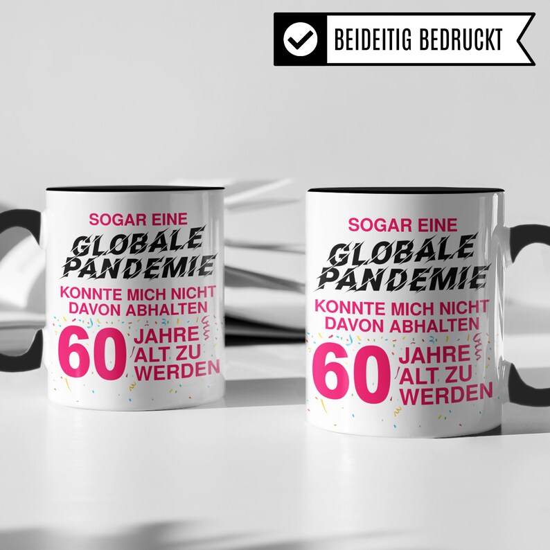 May include: Two white coffee mugs with black handles. Both mugs have a black rim and a pink and black design that says "Even a global pandemic couldn't stop me from turning 60".
