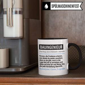 May include: A white coffee mug with a black handle and rim. The mug has black text that reads "BAUINGENIEUR ['bao?inze, ni&oslash;re] Substantiv, maskulin Person, die Probleme erkennt, von denen du weder wusstest, dass es sie gibt, noch in der Lage bist sie zu verstehen und diese auf eine Art und Weise l&ouml;st, die jede Vorstellung &uuml;bertrifft. Synonyme: Genie, Legende"