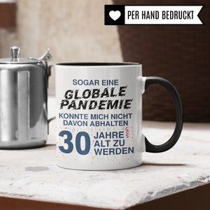 May include: White ceramic mug with a black rim and handle. The mug has a black and white graphic that says "Even a global pandemic couldn't stop me from turning 30." The text is surrounded by colorful confetti.