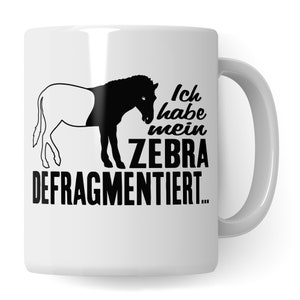 Könnte beinhalten: Weiße Keramiktasse mit einer schwarzen Silhouette eines ZEBRA, das in zwei Hälften geteilt ist. Der Text auf der Tasse lautet "Ich habe mein Zebra defragmentiert..."