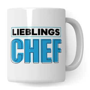 May include: White ceramic mug with a black outline and blue text that reads "LIEBLINGS CHEF".