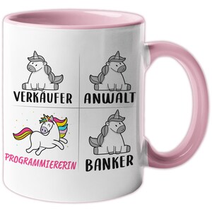 Könnte beinhalten: Weiße Keramiktasse mit rosafarbenem Rand und Henkel. Die Tasse zeigt vier Illustrationen von Einhörnern mit unterschiedlichen Gesichtsausdrücken und den Wörtern "Verkäufer", "Anwalt", "Programmiererin" und "Banker" unter jedem Einhorn.