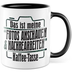 Op de afbeelding: Witte koffiemok met een zwarte rand en handvat. De mok heeft een zwarte camera-afbeelding met de tekst "Das ist meine "Fotos anschauen & nachbearbeiten" Kaffee-Tasse" erop gedrukt.