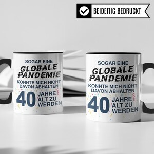 May include: Two white mugs with black handles and black rims. Both mugs have a black and white design with confetti and the text "SOGAR EINE GLOBALE PANDEMIE KONNTE MICH NICHT DAVON ABHALTEN 40 JAHRE ALT ZU WERDEN".