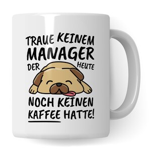 Op de afbeelding: Witte keramische mok met een zwart-witte illustratie van een slapende mops. De tekst op de mok luidt "Traue keinem Manager der heute noch keinen Kaffee hatte!"