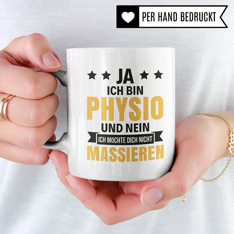 May include: White ceramic mug with a black and gold design. The mug says "JA ICH BIN PHYSIO UND NEIN ICH M&Ouml;CHTE DICH NICHT MASSIEREN" which translates to "Yes I am a physiotherapist and no I don't want to massage you".