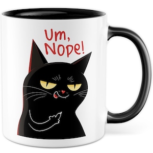Pode incluir: Caneca de café de cerâmica branca com borda e alça pretas. A caneca apresenta um gato preto com olhos amarelos e uma língua vermelha que se projeta. O gato está mostrando o dedo do meio e o texto "Um, Nope!" está escrito em vermelho acima do gato.