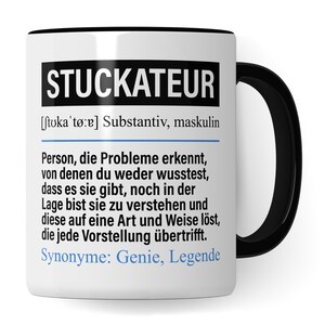 May include: White ceramic mug with a black rim and handle. The mug features a black and white graphic with the word "STUCKATEUR" in large bold letters and a definition of the word in smaller text. The definition reads: "[ʃtʊkaˈtœːɐ] Substantiv, maskulin Person, die Probleme erkennt, von denen du weder wusstest, dass es sie gibt, noch in der Lage bist sie zu verstehen und diese auf eine Art und Weise löst, die jede Vorstellung übertrifft. Synonyme: Genie, Legende"