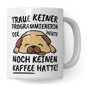 Pode incluir: Caneca de cerâmica branca com um pug de desenho animado dormindo sobre ela. A caneca tem o texto "Traue keiner Programmiererin die heute noch keinen Kaffee hatte!" impresso nela.